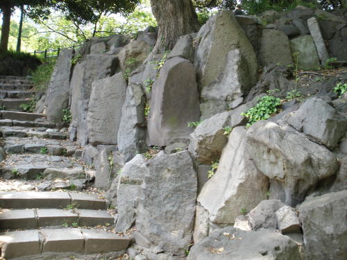 石垣の上に続く石階段と廃材のようなものたち